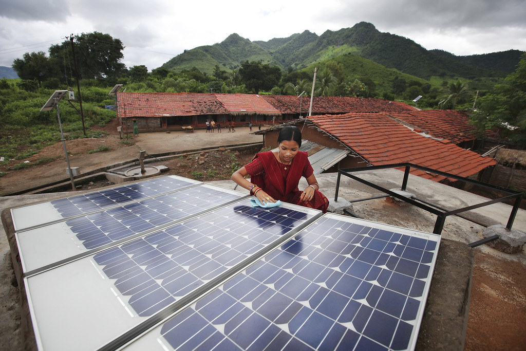 woman in india cleaning solar panel