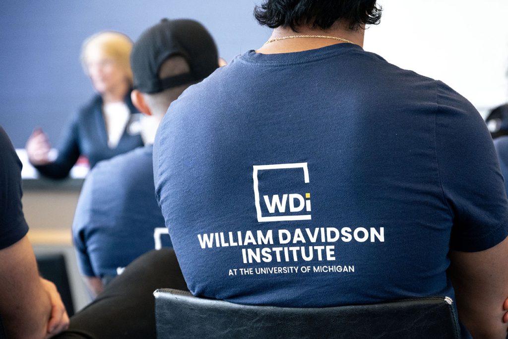 Graduate student wearing a shirt with the William Davidson Institute logo on it.