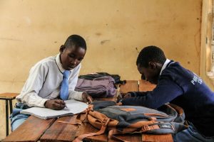a couple of men sitting at a wooden table