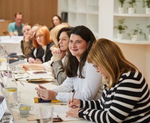 Group session during the NGO leadership workshop in Bratislava. Participants sitting around long tables facing the speaker at the end of the room.
