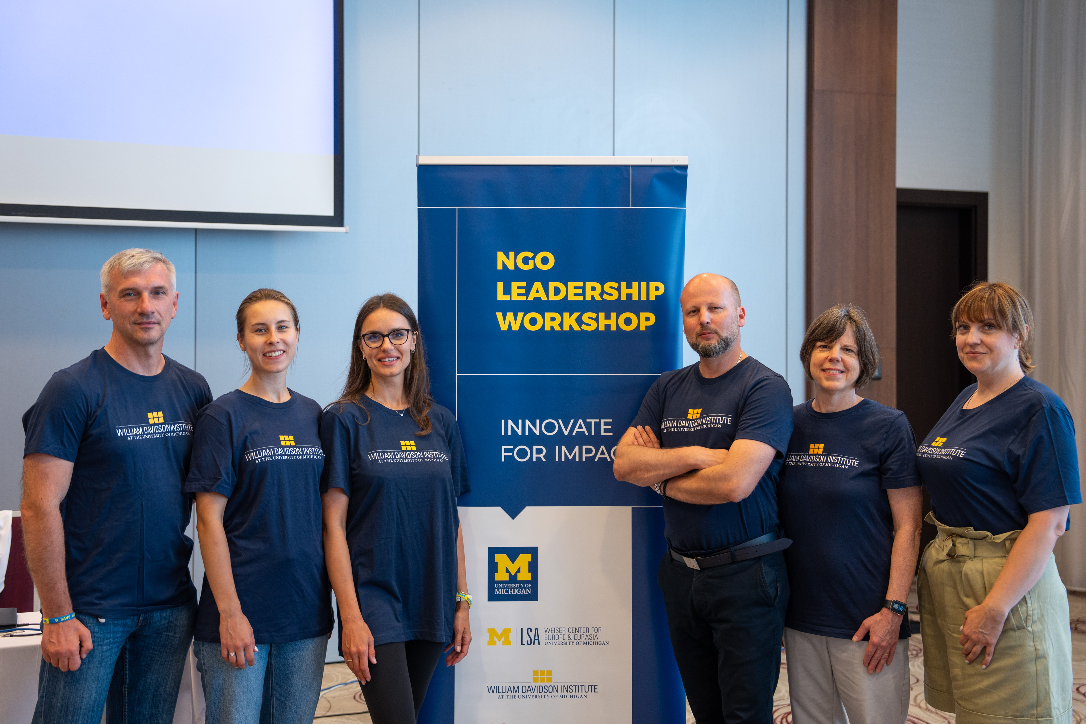 Ukraine participants in the NGO leadership workshop standing next to program banner