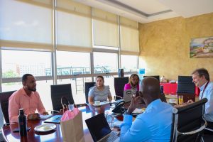 People sitting at a large table in a conference room. Yaquta Fatehi of WDI is sitting at the meeting.