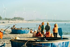 fisherman on beach with windmills in the background