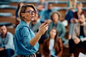 Female speaker giving a presentation during business seminar at convention center.
