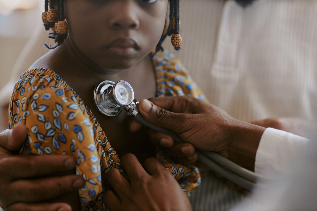 Black child with stethoscope on chest