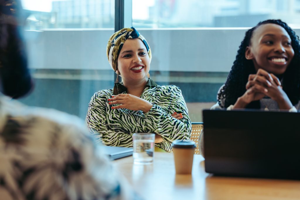 Diverse business meeting with Indian woman in headscarf leading discussion in modern office setting