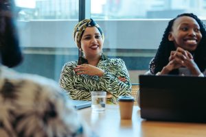 Diverse business meeting with Indian woman in headscarf leading discussion in modern office setting